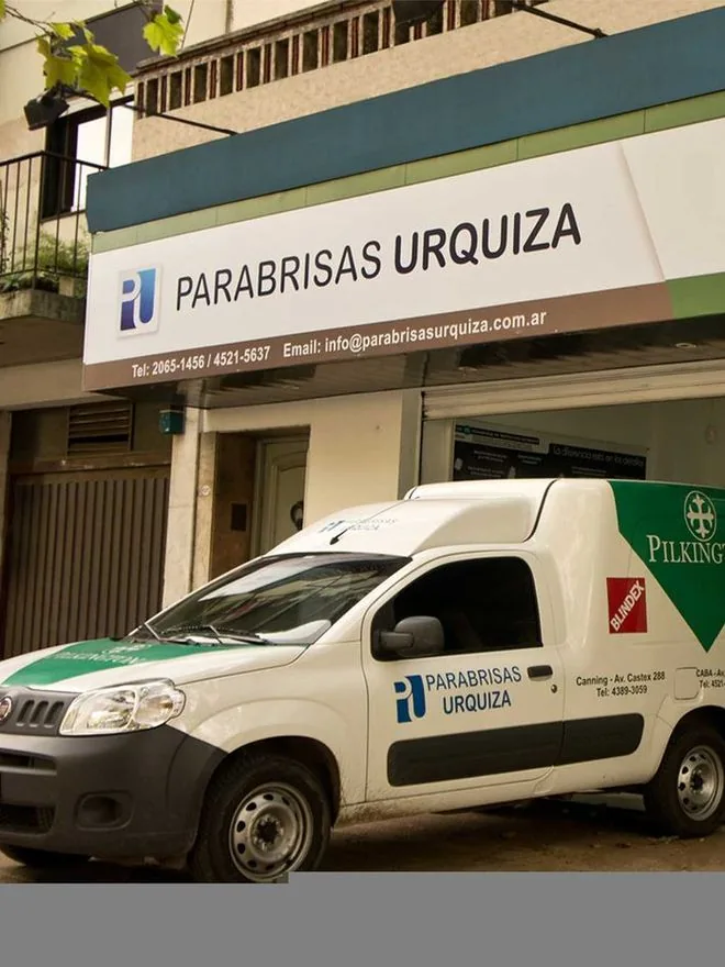 Frente de la Casa Central de Parabrisas Urquiza, en Av. de los Incas 4643, con la camioneta de la empresa