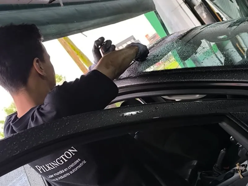 Colocador de Parabrisas Urquiza trabajando sobre el parabrisas de un auto en el taller