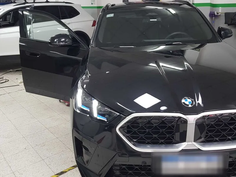 BMW X2 en el taller de Villa Urquiza con la puerta abierta para el cambio del cristal